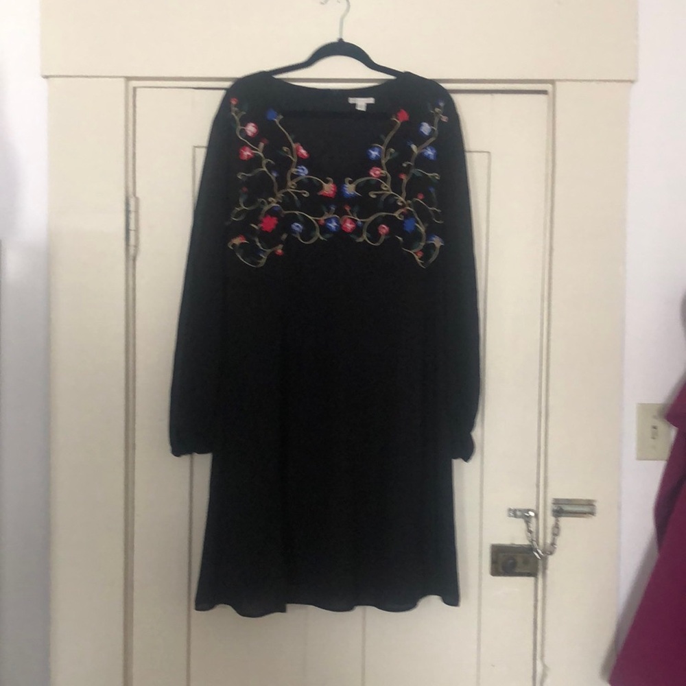 Women’s black dress with embroidered details.